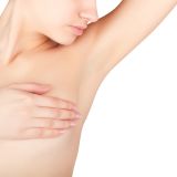 A young woman shows her clean armpit isolated on white background